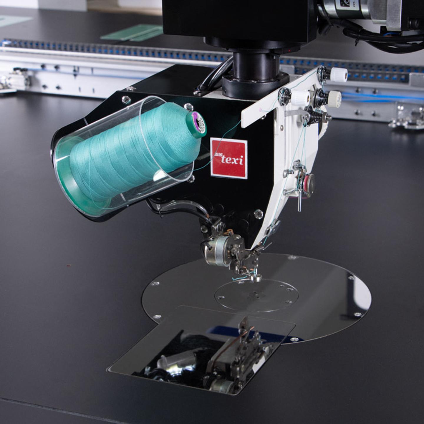 Programmable sewing machine with liftable rotary sewing head and independent drives with extra large sewing field